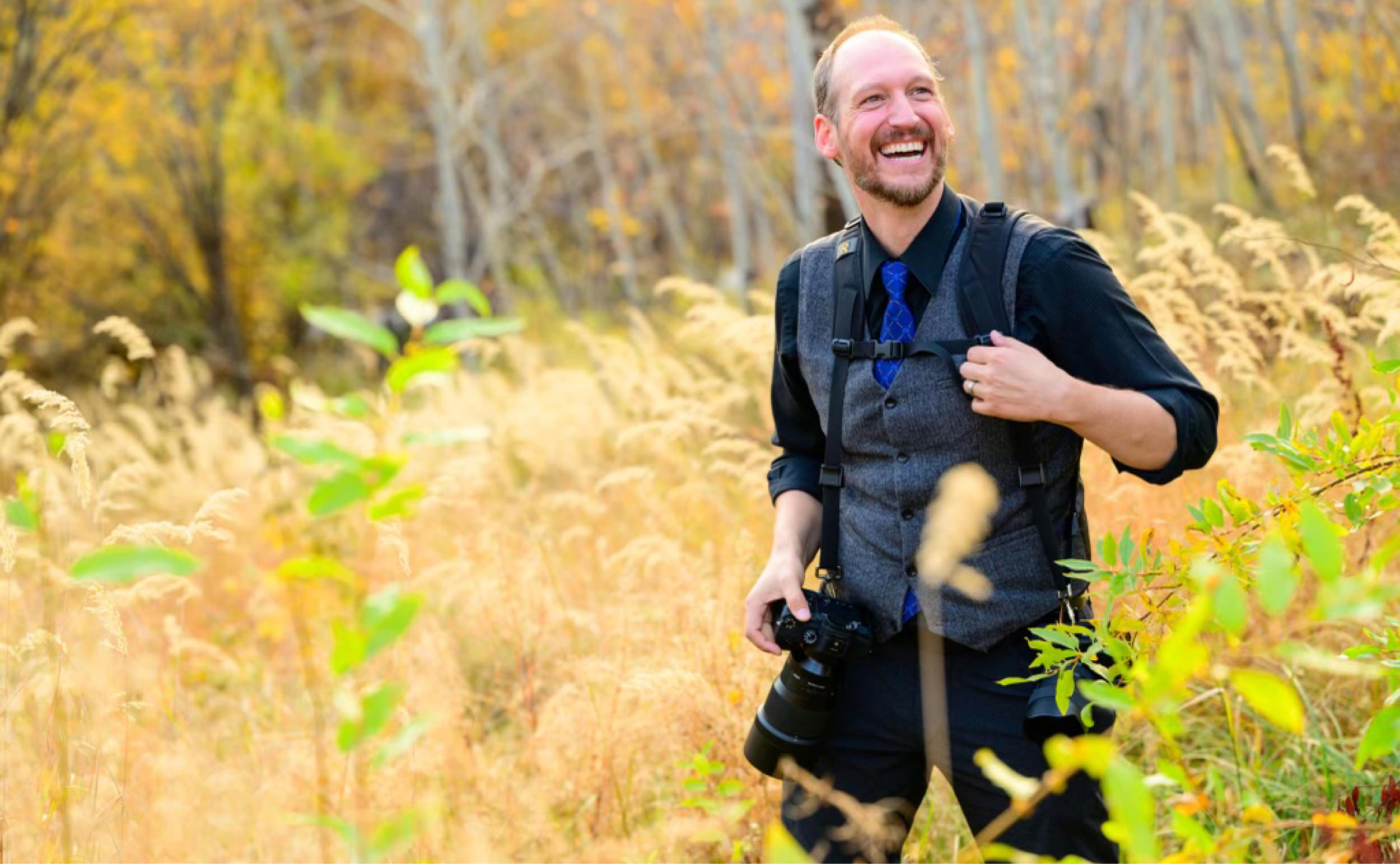 Jeff laughing while out photographing in a field of tall autumn grasses
