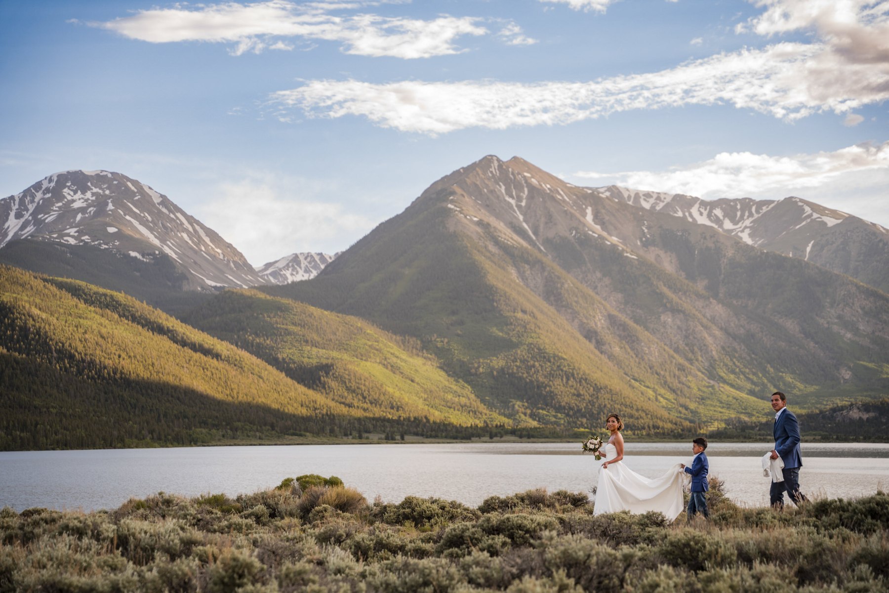 A couple on a hillside above Twin Lakes, with mountains behind them