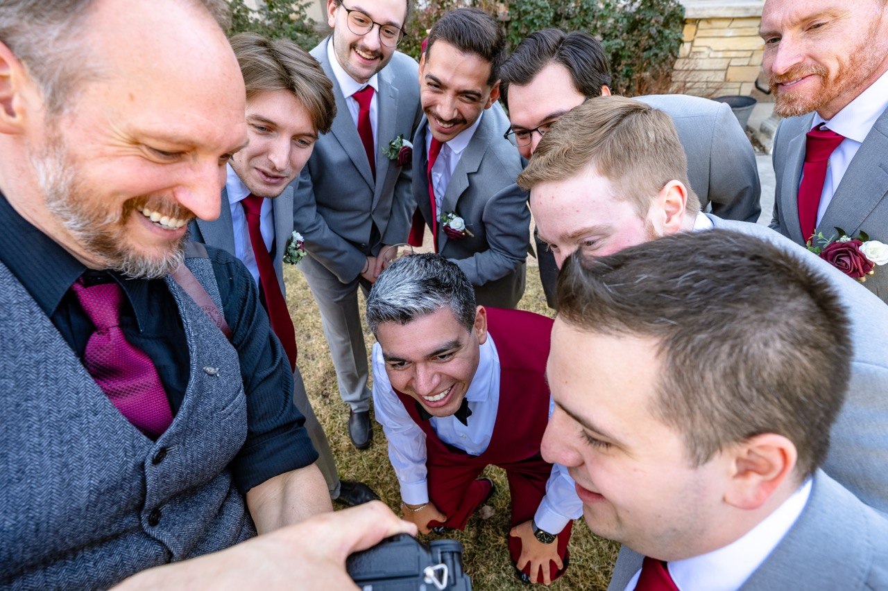 Jeff showing the groomsmen a shot on the back of his camera, all of them laughing