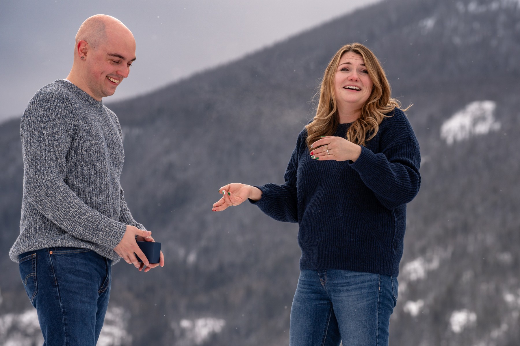 Couple laughing in the snow at Grand Lake moments after a proposal